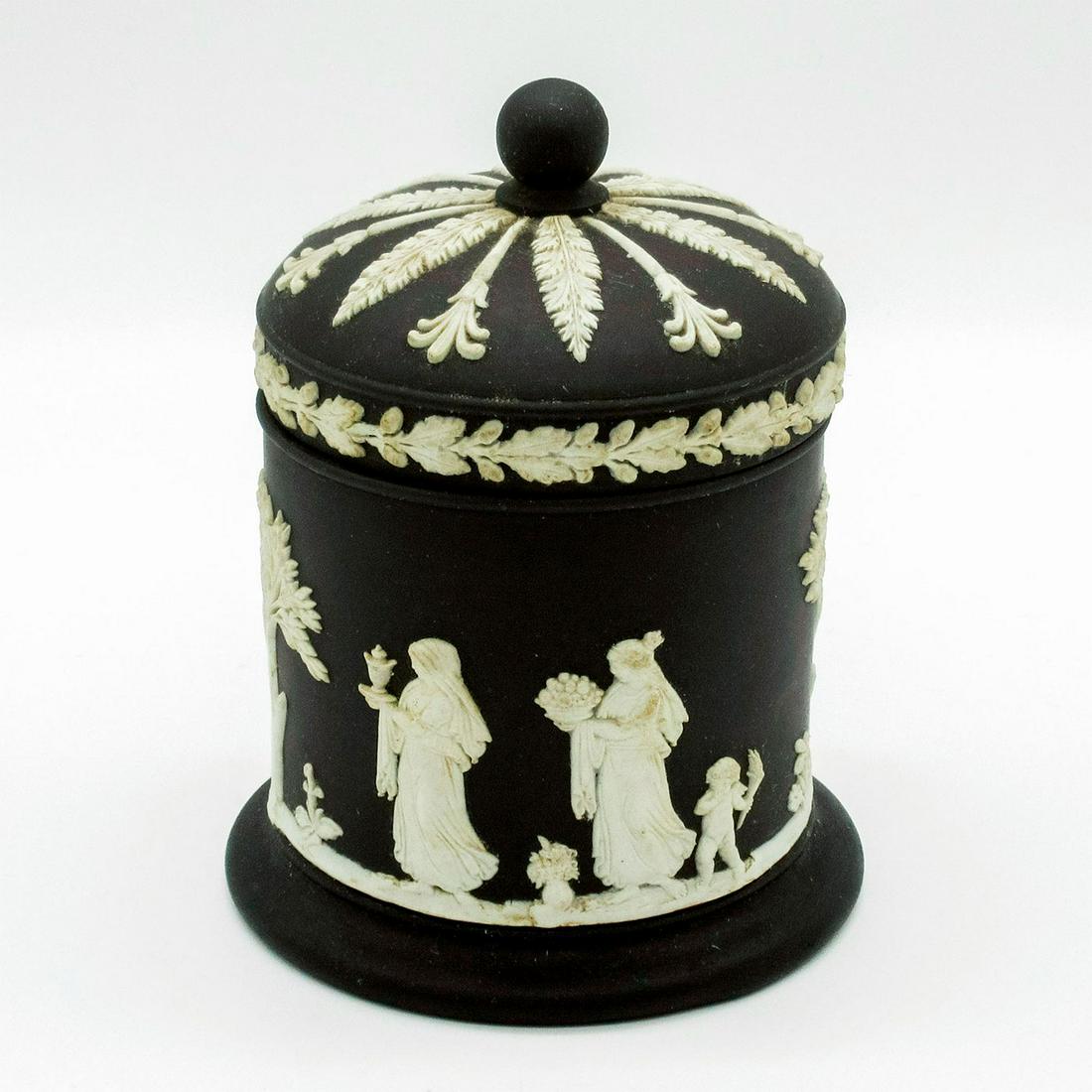 Wedgwood Cream on Black Jasperware Lidded Olympus Jar: Cream colored Olympus pattern in relief; depicting robed figures and cherubs. Wedgwood impressed on base. Age related staining. #wedgwood #jasperware #olympus #jar Issued: 20th c. Dimensions: 4.5"H Ma