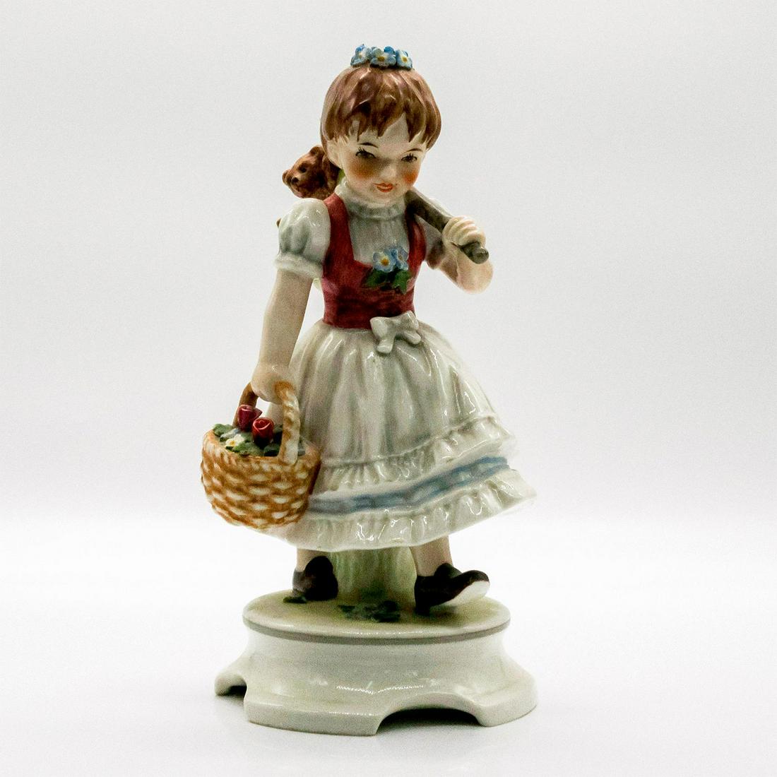 Garden Princess 240 - Goebel Hummel Figurine: Figurine of girl with blue flower crown holding bindle and flower basket. Girl is wearing a hand painted red bodice and white skirt with light blue details. Goebel backstamp. #Goebel #WestGermany #Vin