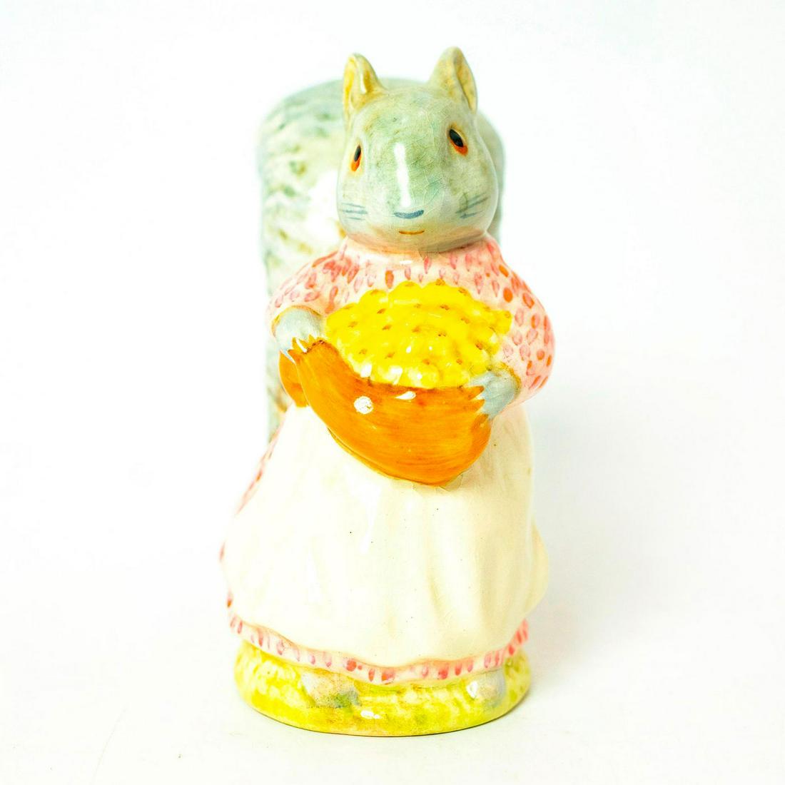 Goody Tiptoes - Gold Oval - Beatrix Potter Figurine: Gold Oval Backstamp. Grey squirrel wearing pink dress and white apron, brown sack with yellow nuts. Artist: Arthur Gredington Issued: 1961 - 1997 Dimensions: 3.5''H Manufacturer: Beswick Country of Or
