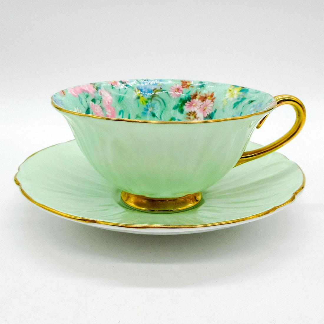 2pc Shelley England Cup and Saucer, Melody: Vintage bone china tea wares; Oleander style. Mint green body with floral chintz pattern interior. Shelley England backstamp. Gold gilt accents. 13412/53 hand-written on base. Cup size - 2.25"H x