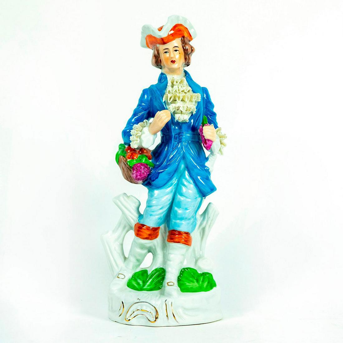 Volkstedt Lace Porcelain Figurine, Man With Grapes: Man in vintage blue suit and tricorne hat holding a basket with berries and grapes. Lace details on collar and sleeves. Unmarked. Wear and tear to lace and cracked left arm. Issued: 19th c. Dimensions