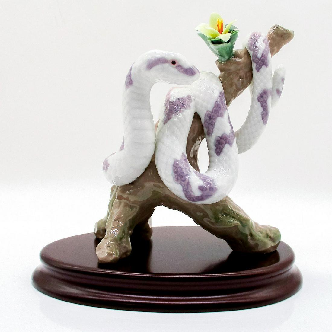The Snake with Base 1006780 - Lladro Porcelain Figurine: Snake wrapped around a branch. Glossy finish; Lladro backstamp on bottom. From the Lladro Zodiac collection. Includes original box and base. A flower is broken. Artist: Joan Coderch Issued: 2001 Dimen