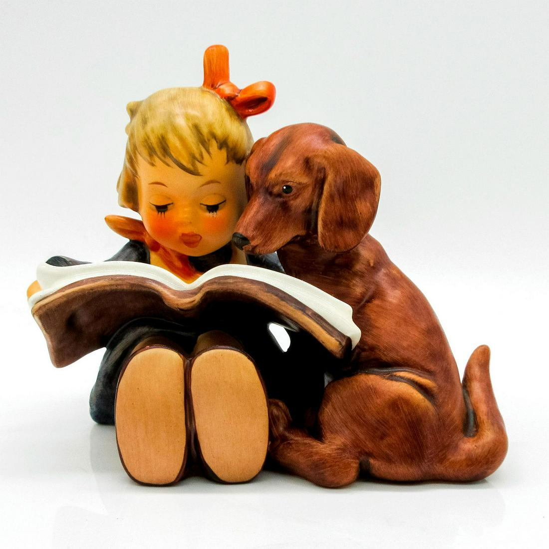 Goebel Hummel Figurine, Proud Moments 800: Matte hand painted porcelain featuring young girl and brown dog reading a book. M.I Hummel impressed on back of girl. Goebal backstamp on bottom. Model number and year impressed on bottom. #puppylove