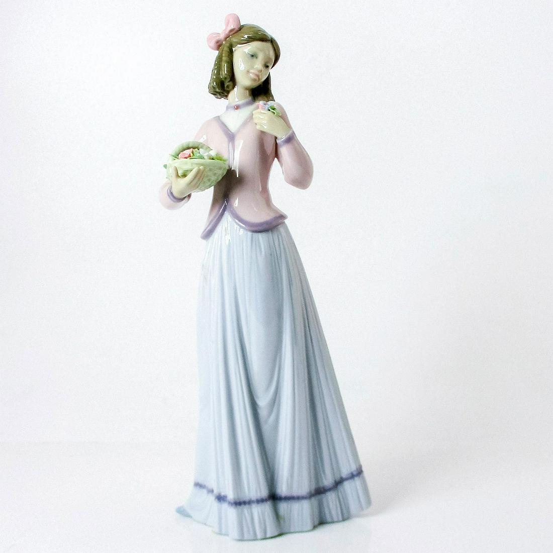 Innocence In Bloom 1007644 - Lladro Porcelain Figure: Glossy finish; Lladro backstamp. Artist: Jose Puche Issued: 1996-1996 Dimensions: 9.75"H x 4.25"W Manufacturer: Lladro Country of Origin: Spain