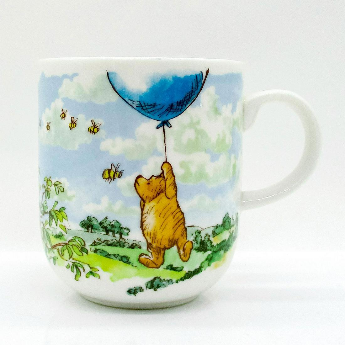 Royal Doulton Porcelain Winnie The Pooh Mug, Summer: Charming mug featuring Winnie holding a balloon as bees fly by. Royal Doulton backstamp. From the Classic Pooh Collection. Issued: 21st c. Dimensions: 3.25"W x 3.75"H Manufacturer: Royal Doulton Count