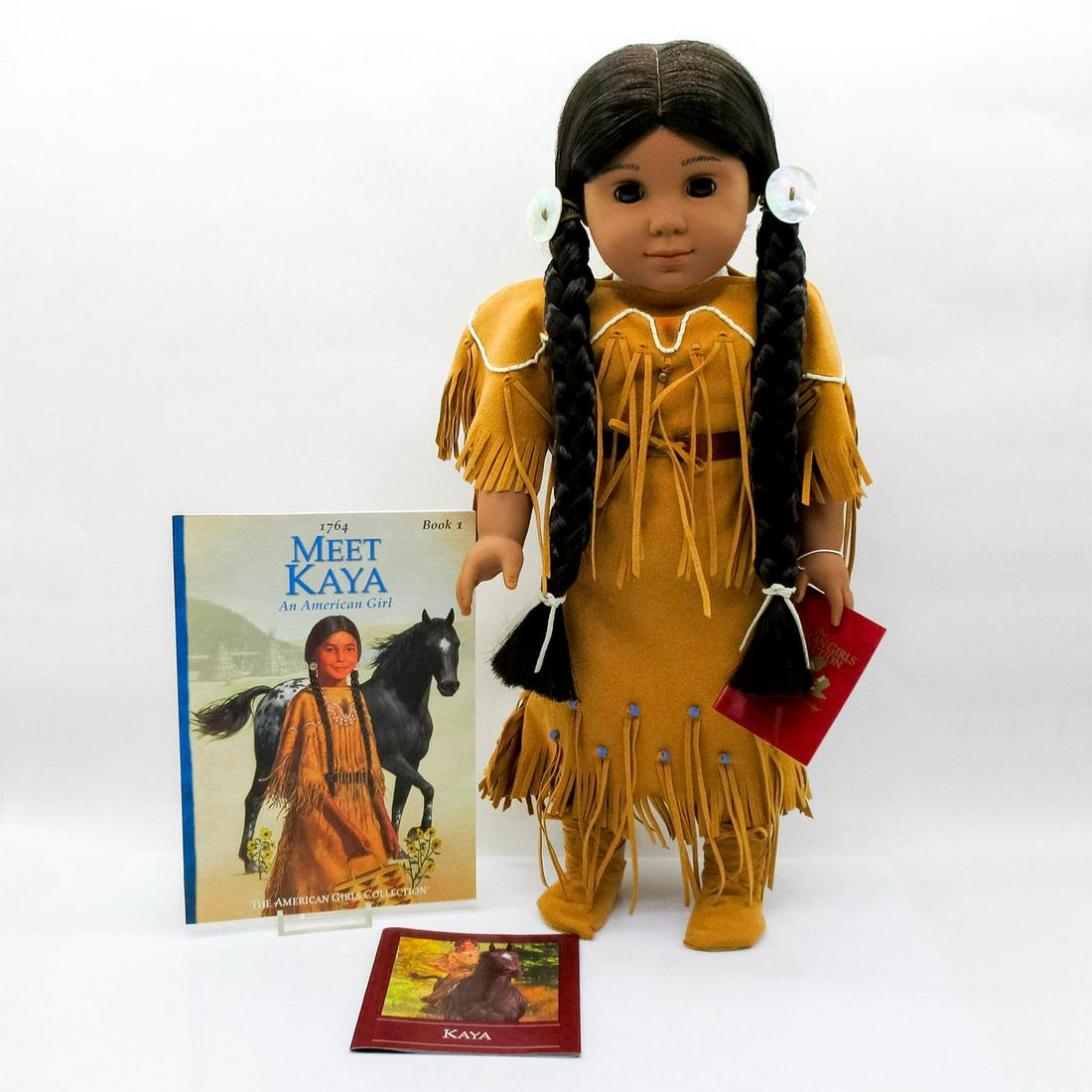 American Girl Kaya Doll and Story Book: Doll with auburn hair in blue and white dress; purple tights; purple coat and hat with black trim; black shoes. In original box 20.5"L x 5"H x 8"W. Pleasant Company stamp on the back of her neck. From