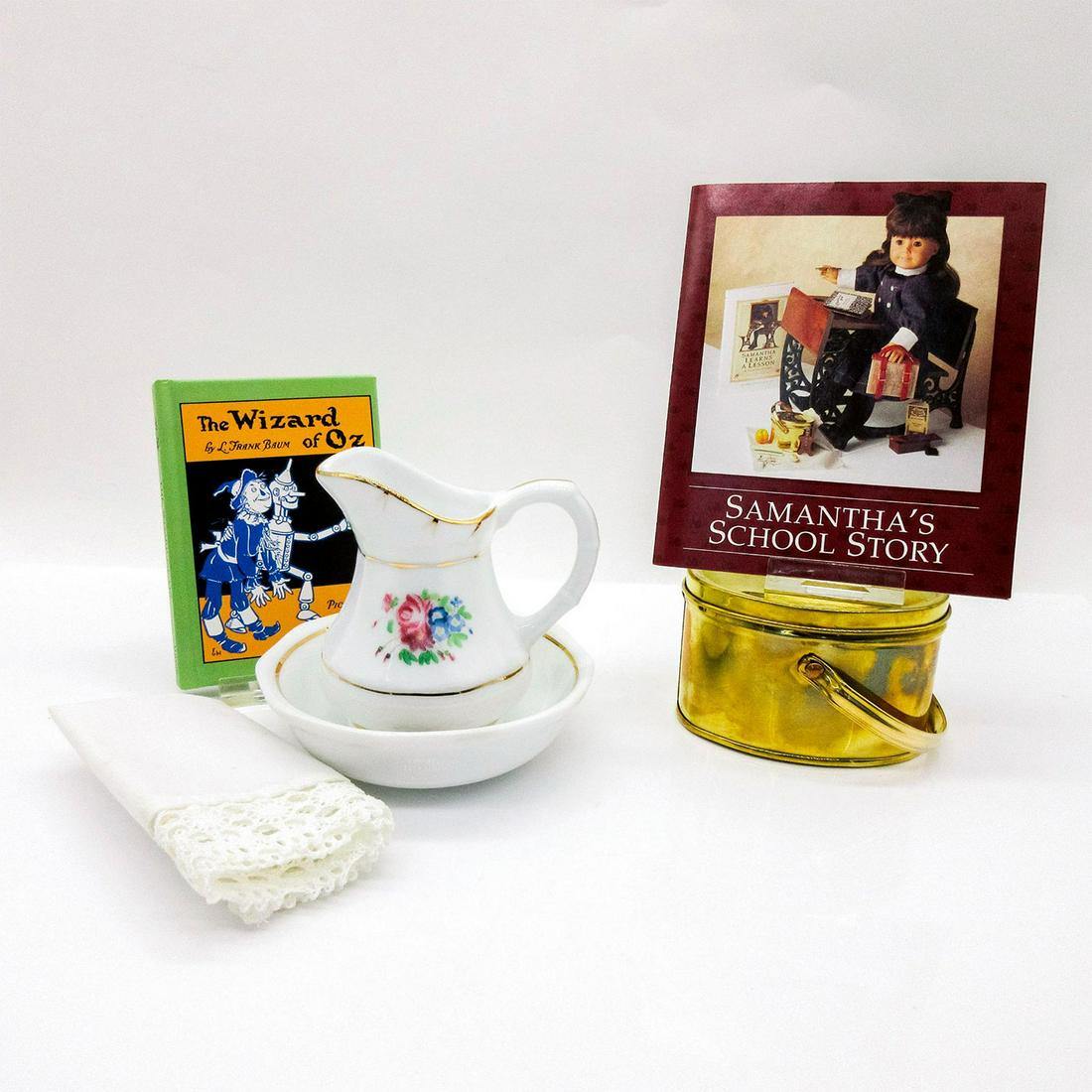 American Girl Samantha, Nighttime Necessities + School Story: Nighttime Necessities includes: wash basin, wash pitcher, towel, Wizard of Oz book. Towel has age spots. The School Story box 5"L x 2.5"H x 5"W is a brass (with age related coloration) handled lunch p