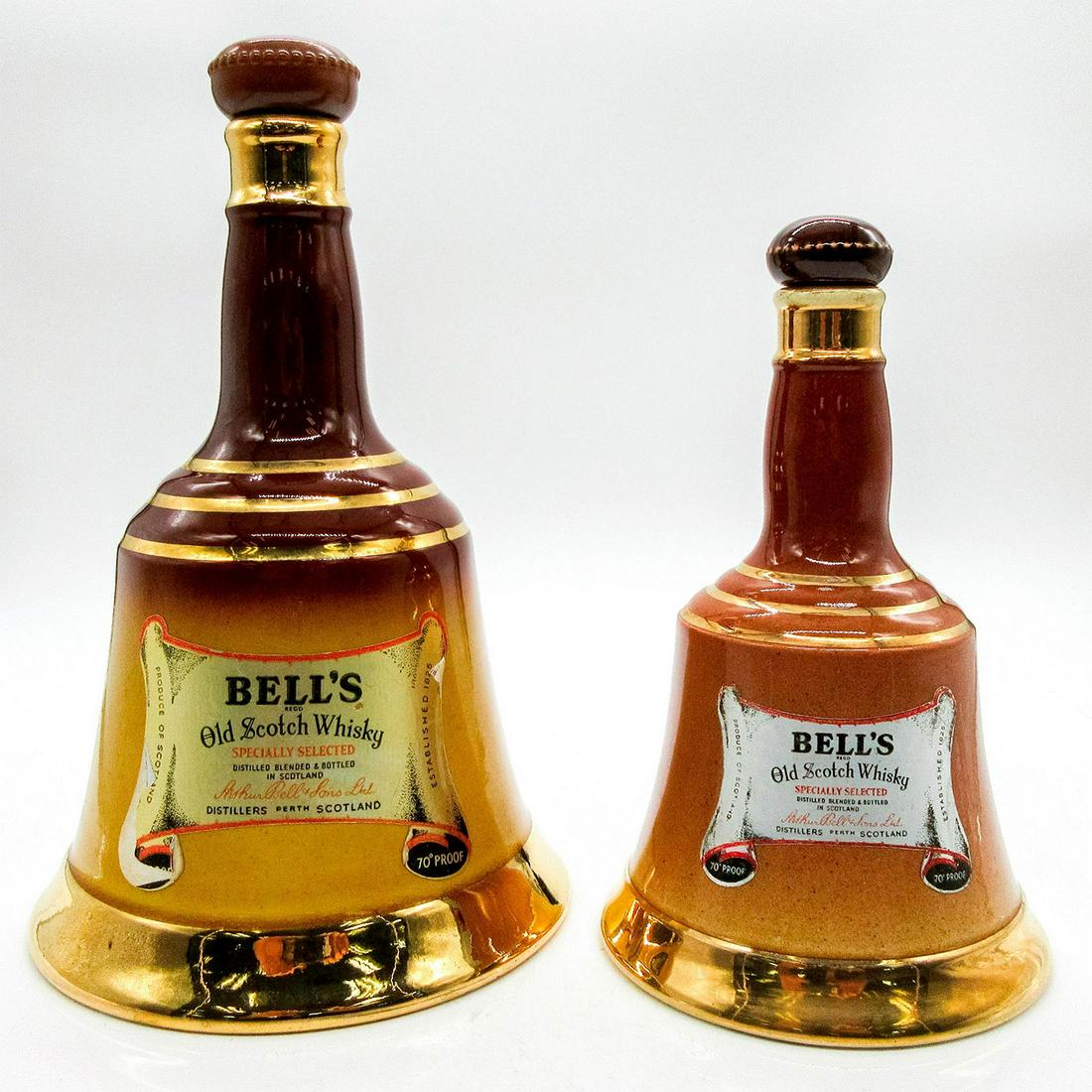 2pc Royal Doulton and Copeland Whisky Bottles: Bell's Old Scotch Whisky. Bell shape in brown and mustard coloration, with gold accents. With stoppers. Factory stickers on front and back. One bottle is approximately 9.5"H with Copland Spode backsta