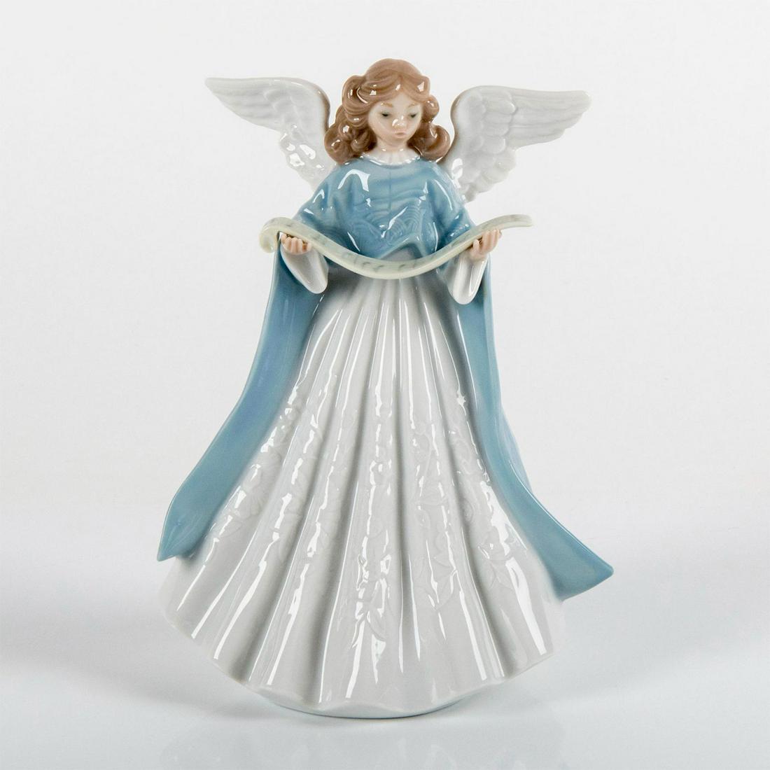 1990 Tree Topper (Blue) 1005719 - Lladro Porcelain Figurine: Glossy finish; Winged angel wearing blue and white robes, holding music sheet. Lladro backstamp. Box not included. Artist: Francisco Catala Dimensions: 7"H Issued: 1990 Manufacturer: Lladro Country of