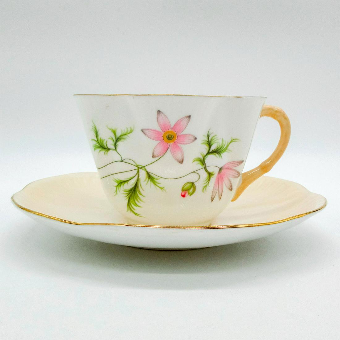 2pc Shelley England Dainty Cup and Saucer, Wild Anemone: Vintage bone china; Dainty shape. Pastel peach body with colorful wild flower pattern. Gilt accents. Shelley England backstamp. 2570/515 hand-written on base. Cup size - 2.5"H x 3.5" diameter (widest)