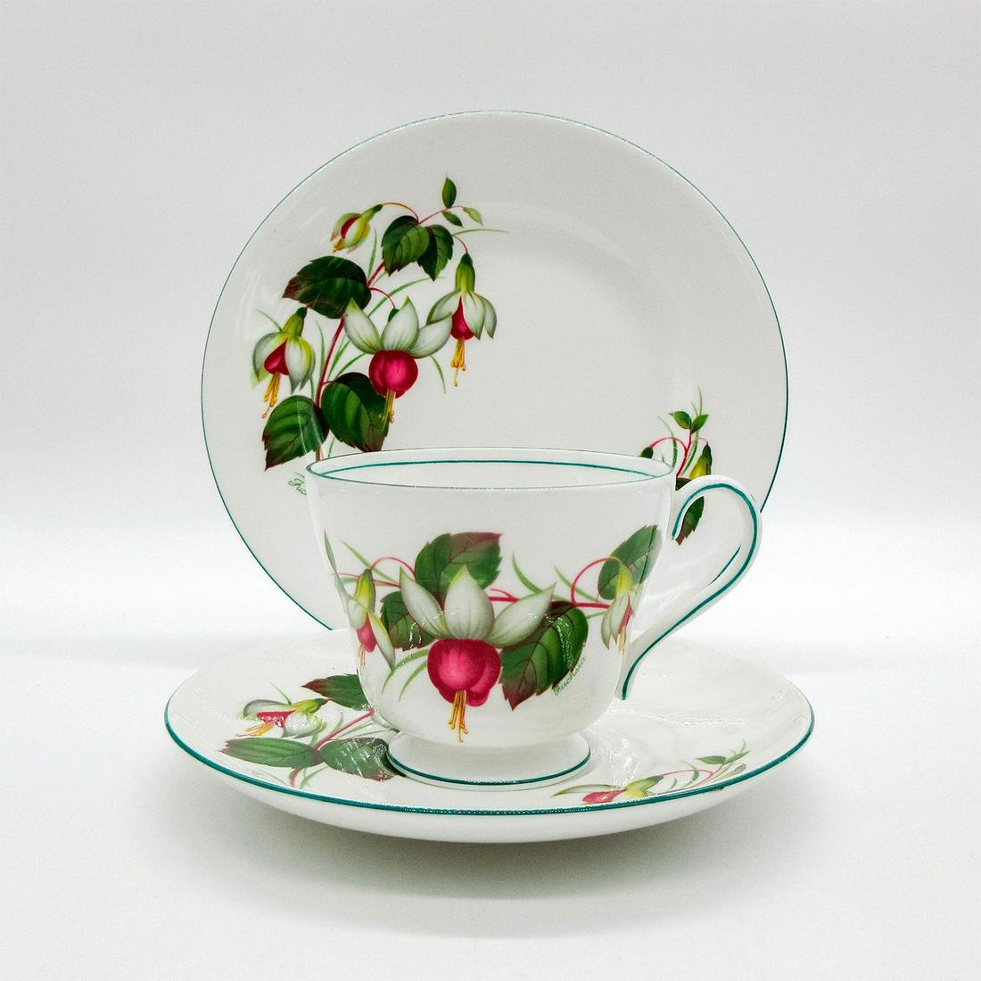 3pc Shelley England Dainty Tea Set Trio, Fuchisia: Bone china tea set; Richmond shape. White and red fuchsia flower pattern with green rim. Shelley England backstamp. 2395 hand-written on base. Cup size - 2.75"H x 3.25" diameter (widest). Saucer size