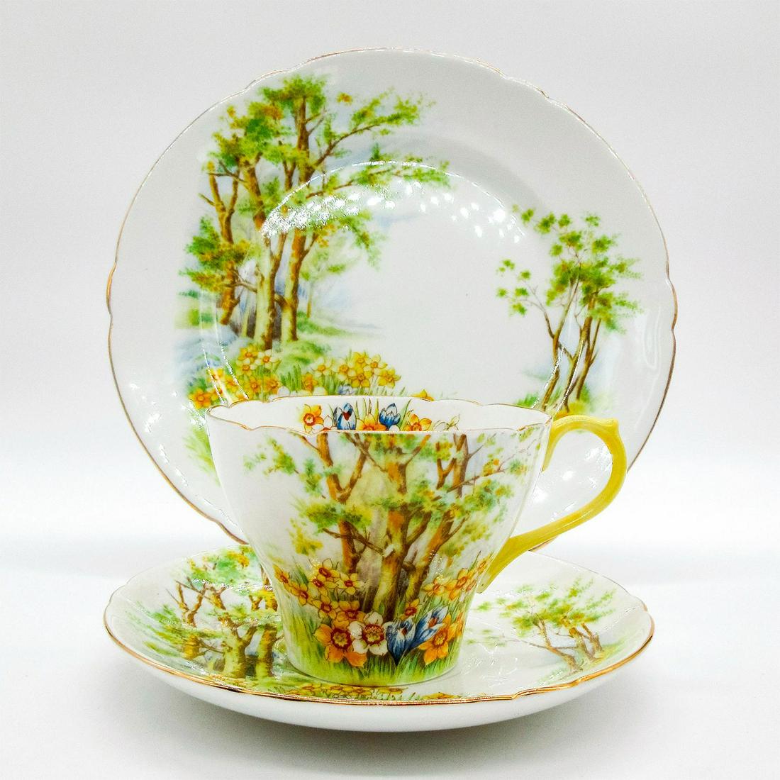 3pc Shelley England Tea Set Trio, Daffodil Time: Bone china tea set; Cambridge shape. Yellow and white daffodils in the woods. Gold gilt accents. Shelley England backstamp. 13370 stamped on base. Cup size - 2.5"H x 3.5" diameter (widest). Saucer siz