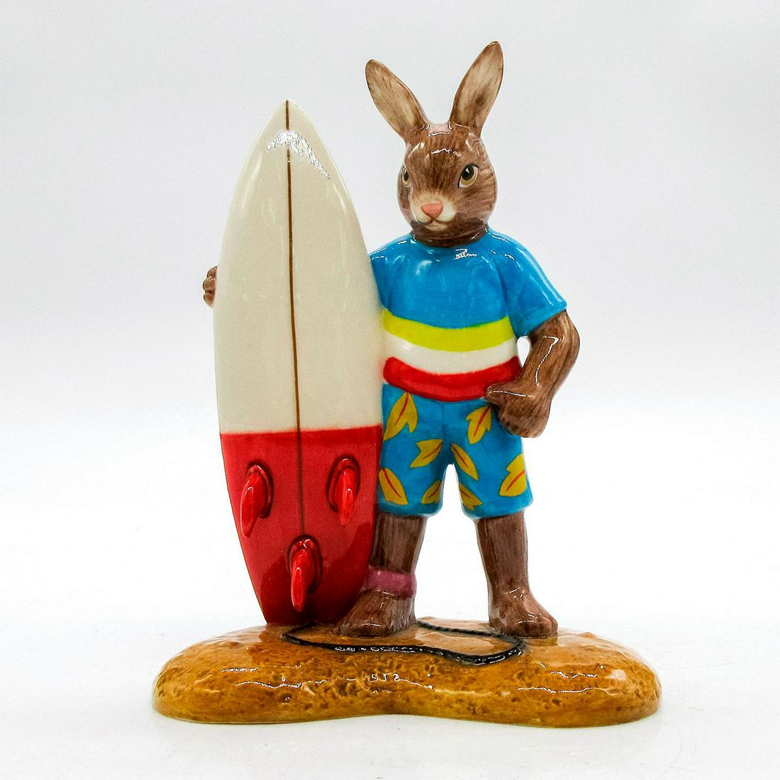Wax On DB509 - Royal Doulton Bunnykins: Brown bunny wearing a blue patterned shirt and shorts, holding a cream and red surfboard. Bunnykins backstamp. Issued: 2013 Dimensions: 4.5"H Edition Number: 553 Edition Size: 1000 Manufacturer: Royal
