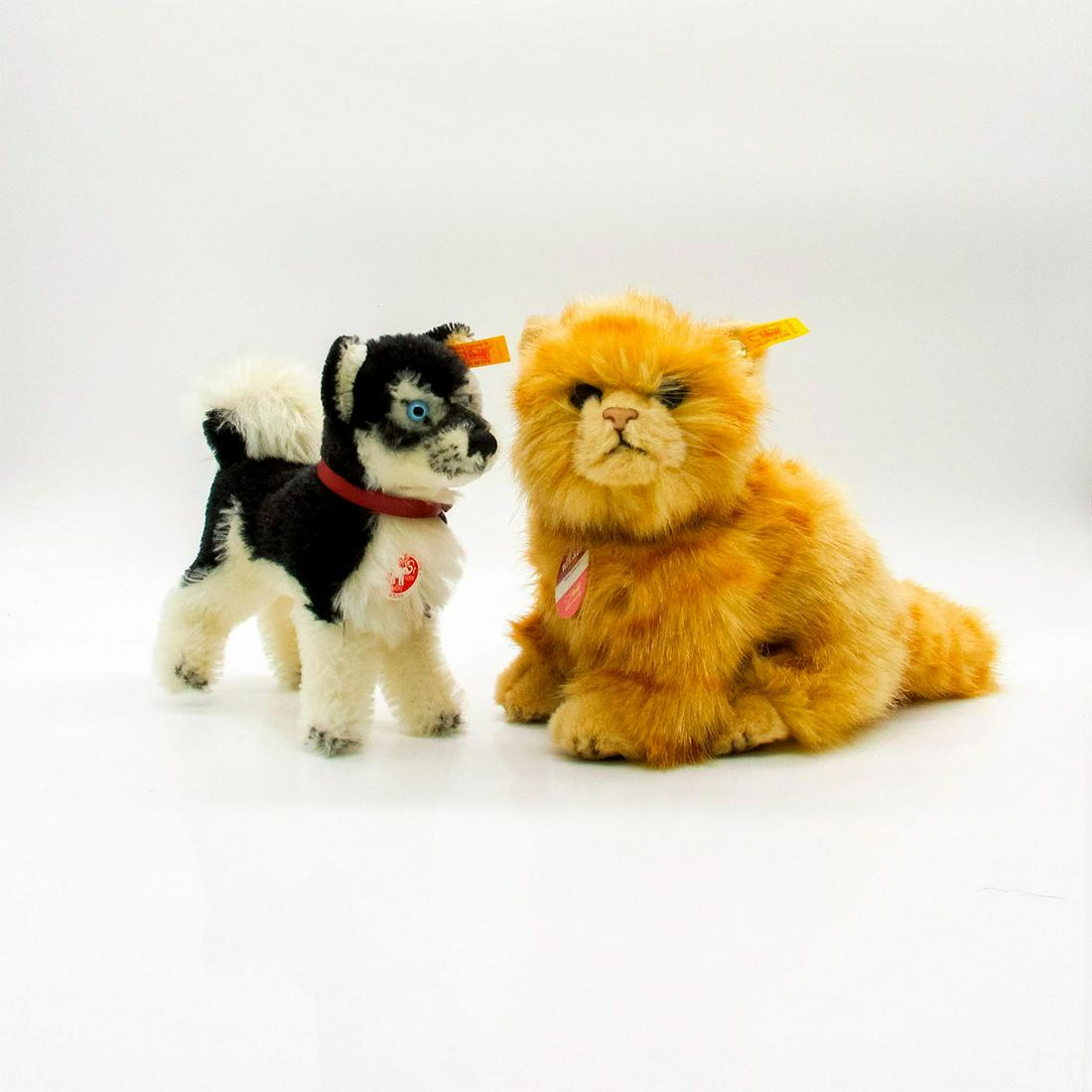 2pc Steiff Stuffed Animals, Whitey and Whiskas: Whitey is a highly detailed black and white husky with blue eyes. Whiskas is an orange fluffy tabby with gray eyes. Whitey has a wire frame, curled fluffy tail, and stitched nose. Comes with a red col