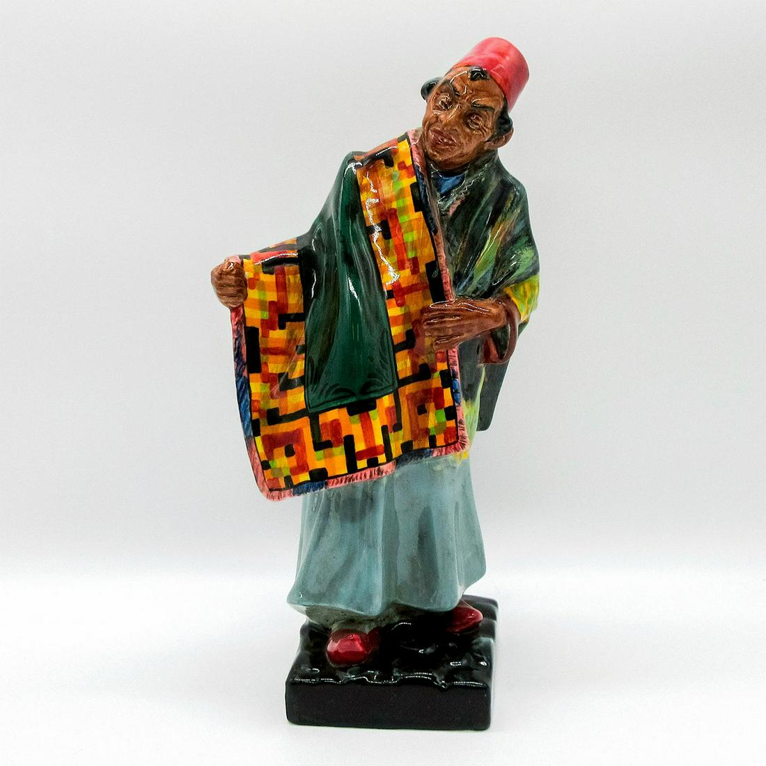 Carpet Seller HN1464A (Hand Closed) - Royal Doulton Figurine: Polychrome; glazed porcelain. Doulton backstamp.