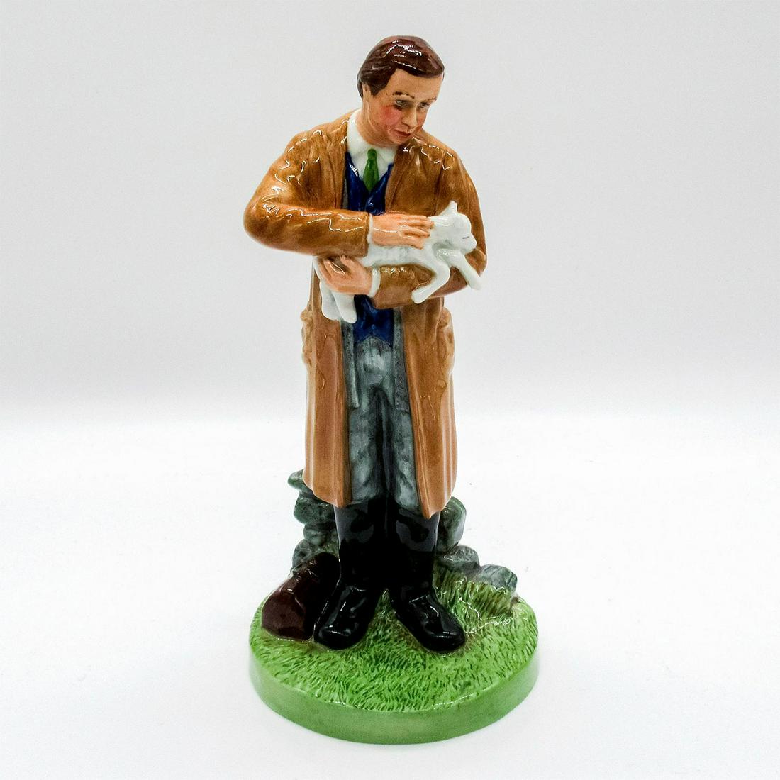 Country Veterinary HN4650 - Royal Doulton Figurine: Man in light brown coat cradling a young lamb in his arms.