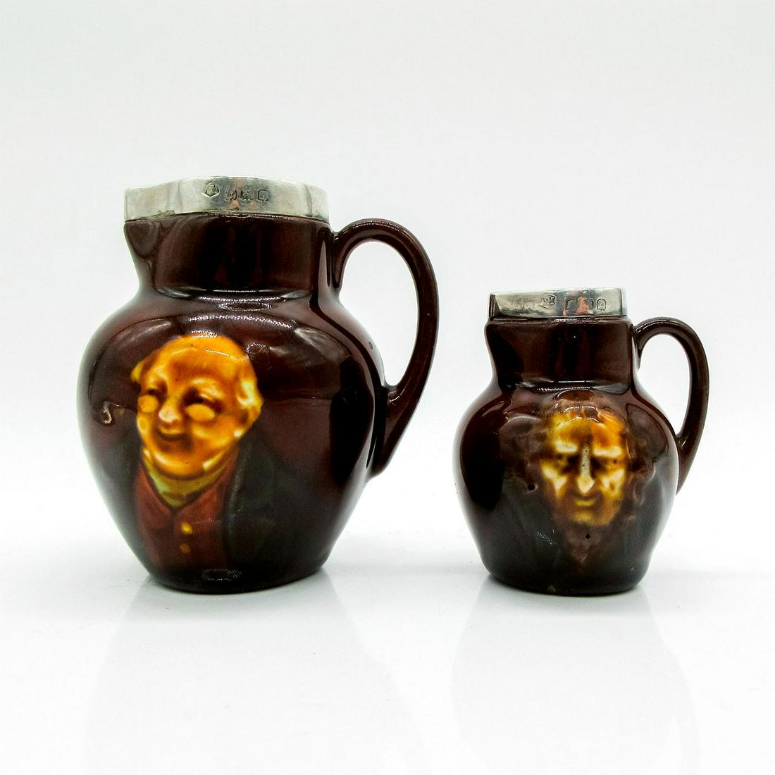 2pc Miniature Jugs, Dickens - Royal Doulton Kingsware: Dark, rich brown glazed body; silver rimmed. Feature Mr. Pickwick and Fagin in low relief.