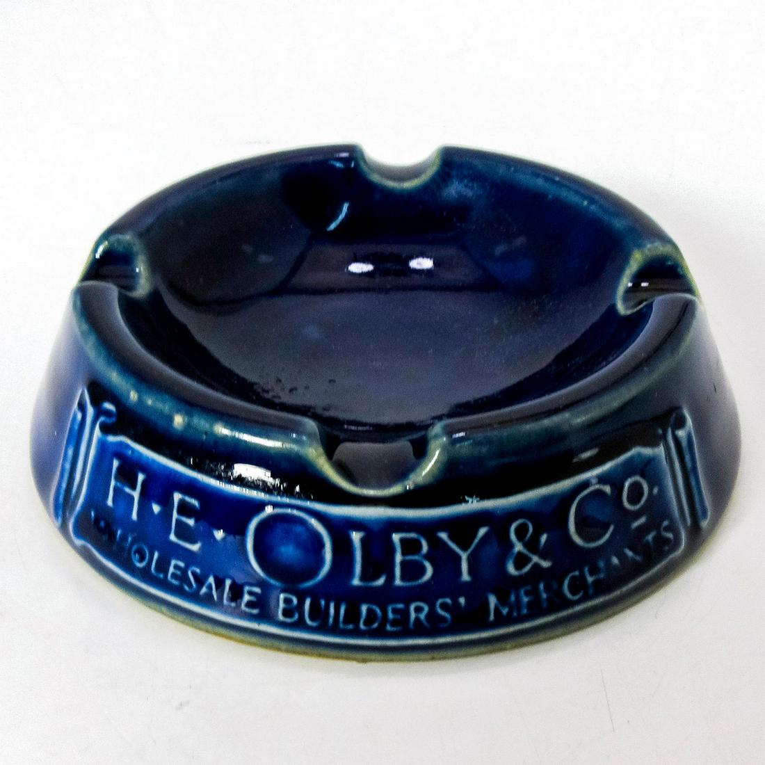 Royal Doulton Adware Ashtray, H.E. OLBY & Co.: Glossy finish in blue coloration, marked "H E OLBY & Co Wholesale Builders Merchants" on side of front.
