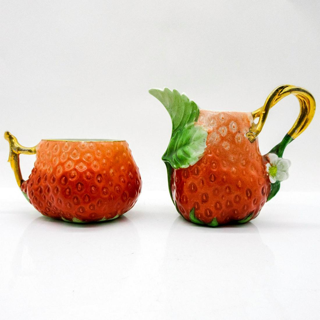 Vintage Porcelain Creamer and Tea Cup, Strawberry: Whimsical strawberry creamer 3.75"H with leaves, flowers and gilt handle in the style of Royal Bayreuth. Tea cup 2.25"H. Age related wear seen on handles as faded gilt finish. Issued: 20th c.