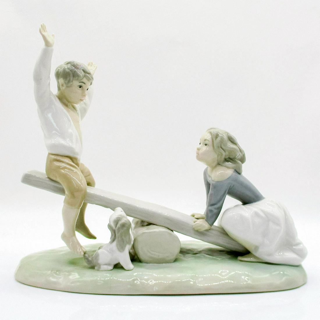 See-Saw 1004867 - Lladro Porcelain Figurine: Boy and girl on a see-saw with a dog sitting next to them. Glossy finish; Lladro backstamp on bottom. Several cracks to the base. Artist: Fulgencio Garcia Issued: 1974-1996 Dimensions: 7.75"H x 9"W Ma
