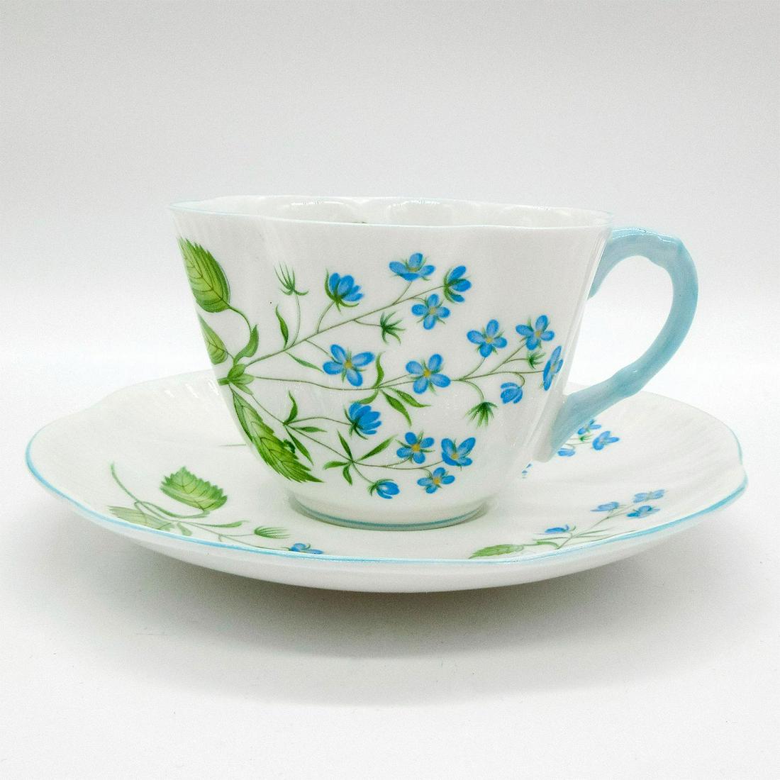 2pc Shelley England Cup and Saucer, American Brooklime: Vintage bone china tea wares; Dainty shape. Soft blue and yellow floral motif with robin egg blue trim. Shelley England backstamp. 14060 hand-written on base. Scalloped edge. Cup size - 2.5"H x 3.5" d