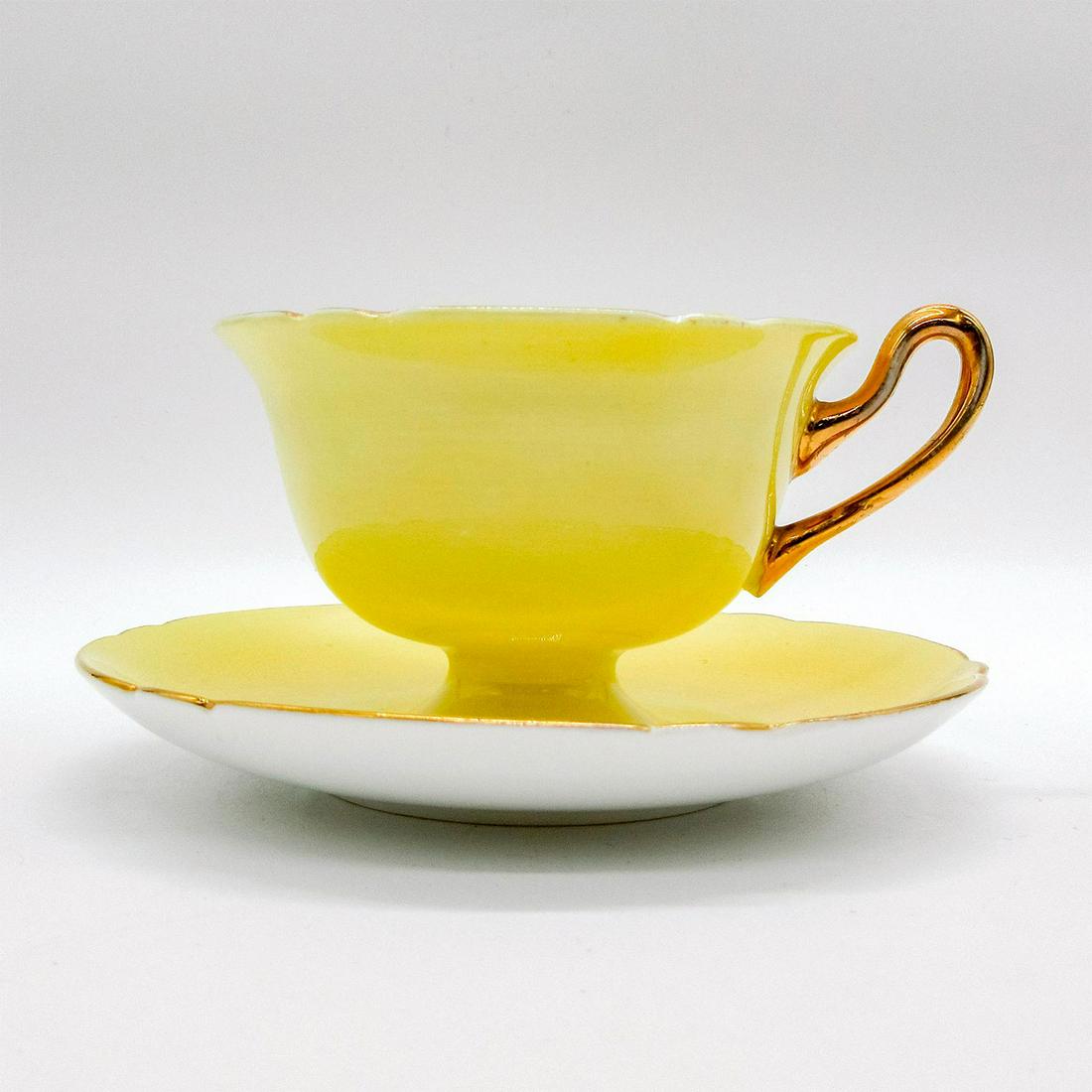 2pc Shelley England Gainsborough Cup and Saucer: Vintage bone china tea set. Custard yellow body with pink and purples flower pattern interior. Gilt accents. Shelley England backstamp. Cup size - 2.75"H x 4" diameter (widest). Saucer size - 0.75"H x