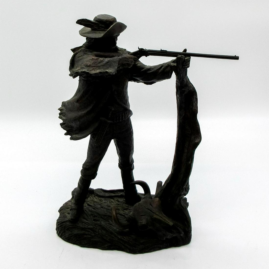 The Western Heritage Museum Sculpture, The Buffalo Hunter: Features man in hat and western garb holding a rifle and aiming. Cold cast bronze sculpture. Includes instructions on how to care for piece. Includes colored brochure photo of piece. Includes letter t