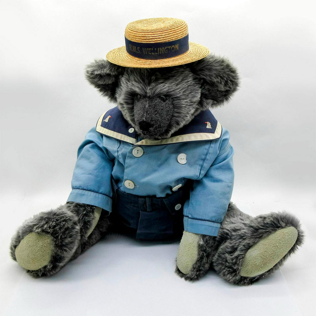 GenaBears Teddy Bear, Sailor: A grey bear in a blue navy uniform. Printed on the ribbon of his hat is H.M.S. Wellington, the retired Royal Navy ship currently docked in London. Arms and legs are moveable and padded with suede. Sit