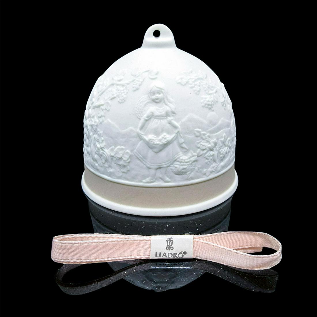 Fall Bell 1017615 - Lladro Porcelain: Matte porcelain white and tan bell ornament. Decorated in reliefs of a girl harvesting grapes from the vineyard. Includes original box, and pink Lladro ribbon. Lladro, and Collector's Society Lladro b