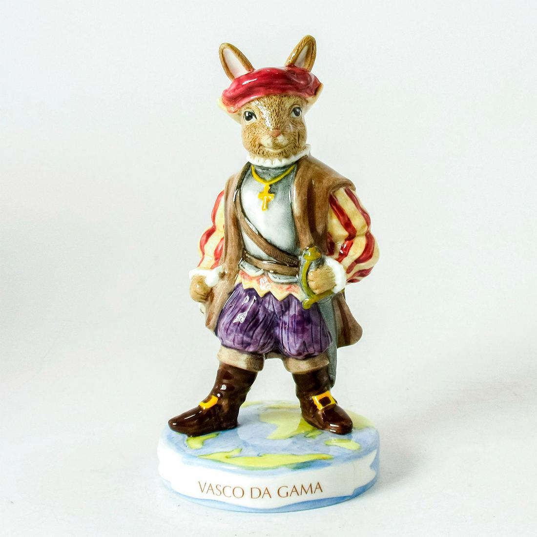 Vasco Da Gama DB413 - Royal Doulton Bunnykins: Bunny wearing purple trunks, red and white striped doublet matching hat, grey vest, and brown cape. Explorers series. Bunnykins backstamp. Original box and certificate of authenticity included. Artist