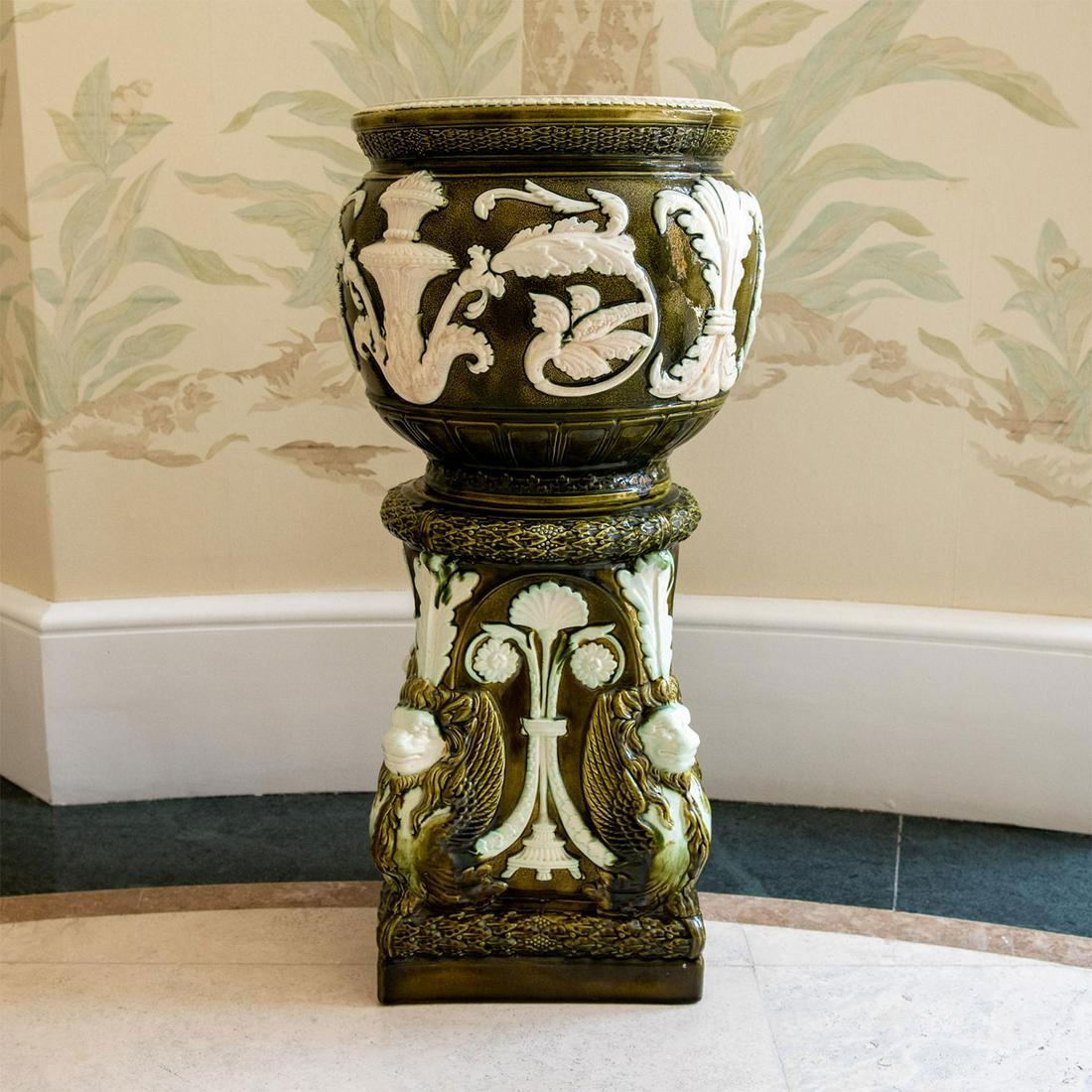 Antique English Wardle Majolica Jardiniere with Stand: Earthenware bowl with stand in green and white. Floral high relief decorations along with mythological creatures depicted on the corners. Circa 1875-1910. Wardle England impressed marks on the bottoms