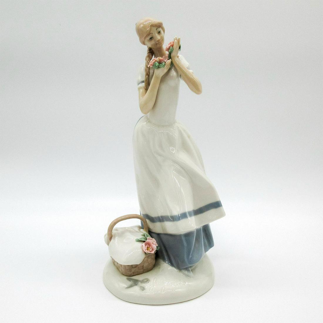 Franklin Mint Fine Porcelain, Cecilia The Carnation Maiden: Limited edition. An Lladro inspired glossy figure. A woman holding pink flowers in her hands. Franklin Mint backstamp. Artist's engraved signature on the base. #FranklinMint #Figure Artist: Fulgencio