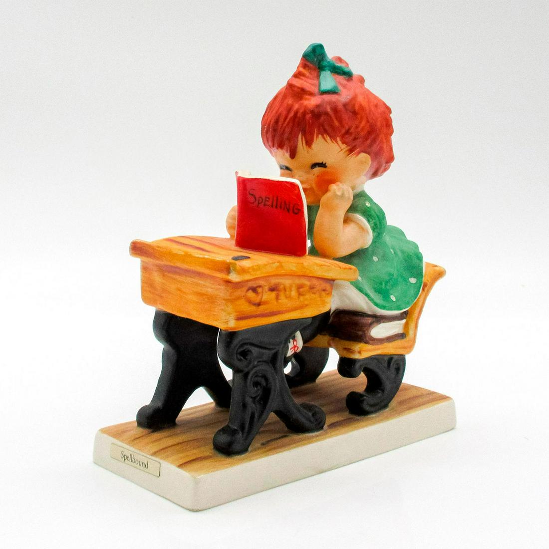 Goebel Red Heds Figurine, Spellbound BYJ19: Vintage piece featuring little girl sitting in chair at old school desk holding book titled Spelling. Goebel backstamp. #goebel #germany #redheads #spelling Artist: Charlot Byj Issued: 1958 Dimensions