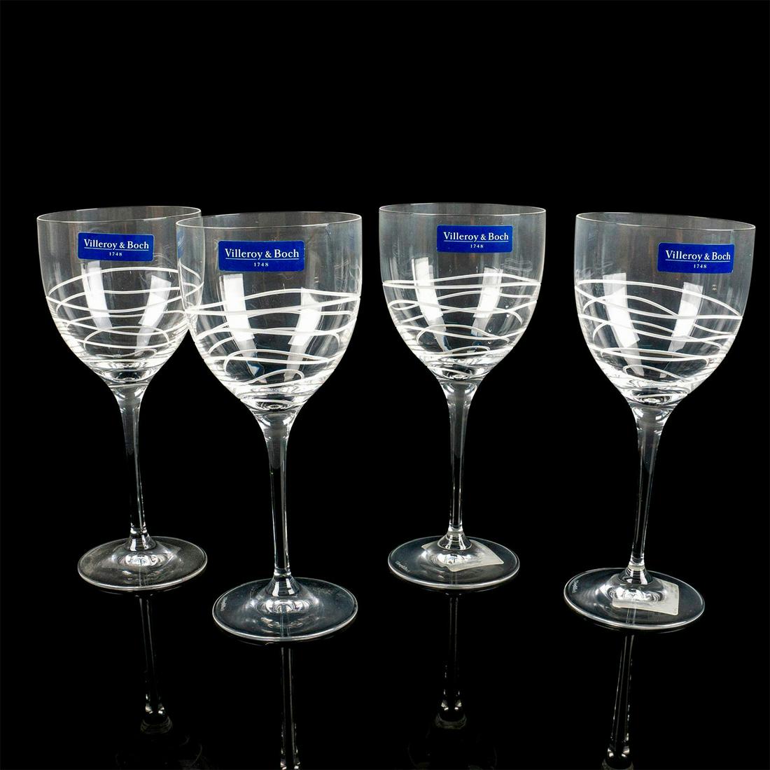 4pc Villeroy and Boch Wine Goblets, New Wave: Clear lead crystal stemware; thin stem, etched wavy lines on bowl. Comes with original box. Villeroy & Boch sticker on side. Box size - 7.5"H x 6.75"W. Issued: 2004 - 2009 Dimensions: 7.25" H x 3.25 M