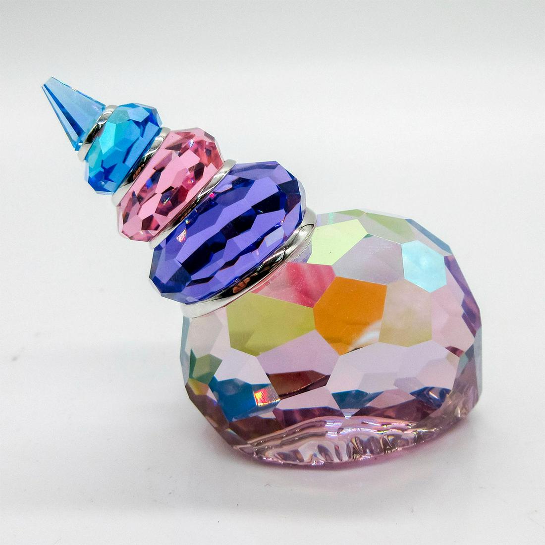 Swarovski Crystal Figurine, Corunna Shell: Lead crystal, depicting a spiral shell. Clear, with purple, blue, and pink coloration. Swarovski etched backstamp. Comes in original box which is 3.5"L x 3.5"W x 2"H. Issued: 20th c. Dimen