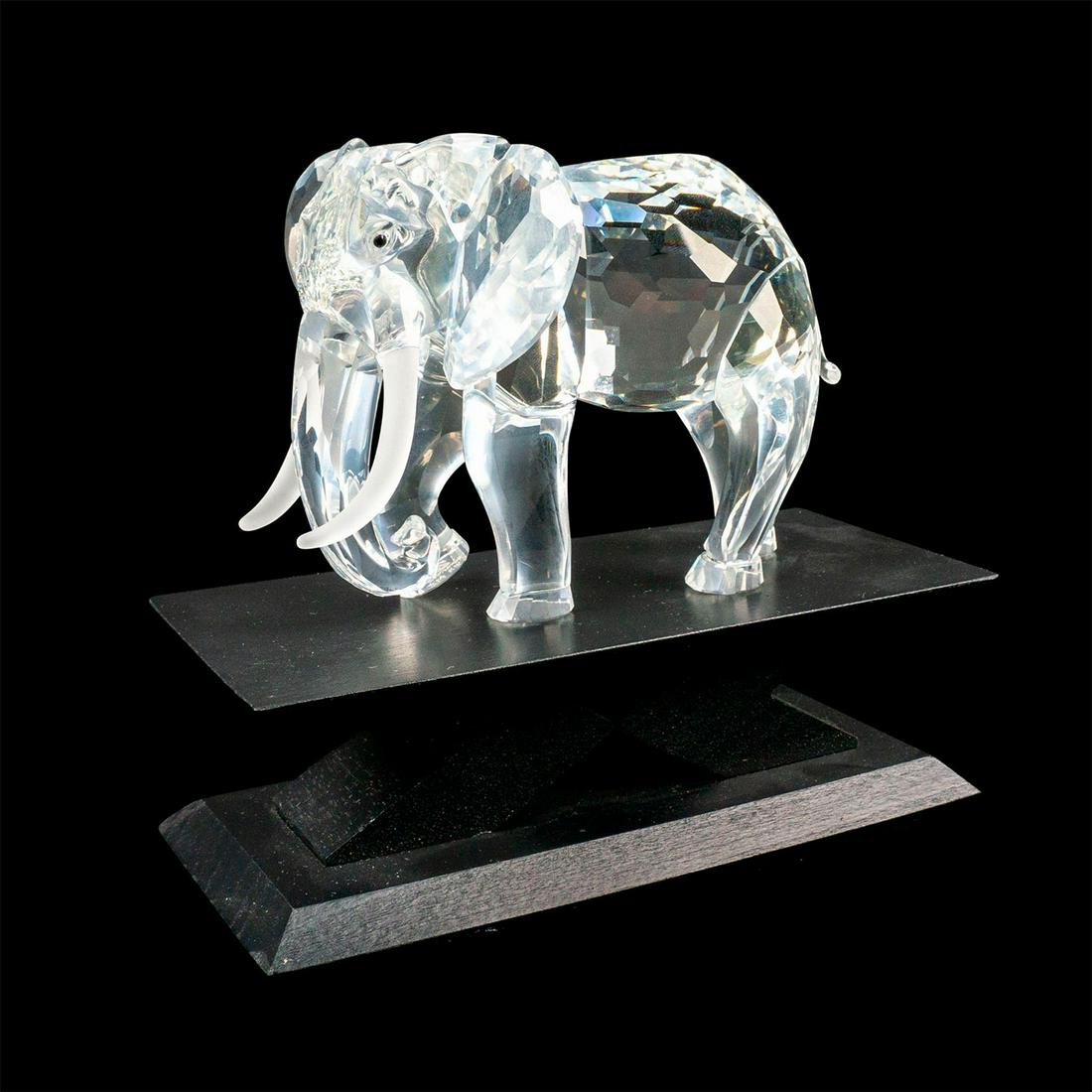 Swarovski Crystal Figurine, The Elephant + Base: Lead crystal figure elephant with frosted tusks and polished Jet gemstone eyes. This piece was released in 1993 for the Swarovski Collectors Society. This sculpture was the second issue of the "In