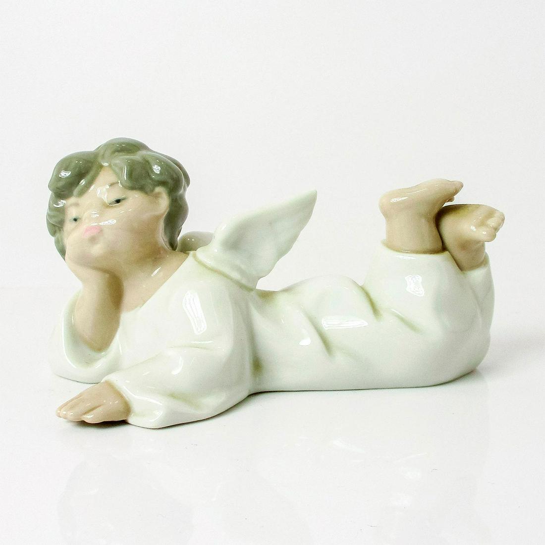 Angel, Reclining 1004541 - Lladro Porcelain Figurine: Glossy finish; Lladro backstamp. Artist: Fulgencio Garcia Issued: 1969 Dimensions: 2.25"H x 5.5"W Manufacturer: Lladro Country of Origin: Spain