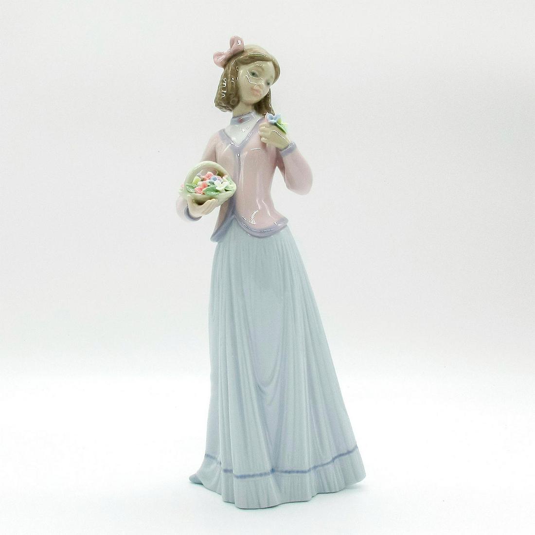 Innocence In Bloom 1007644 - Lladro Porcelain Figurine: Glossy finish; Lladro backstamp. Original box included. Artist: Jose Puche Issued: 1996-1996 Dimensions: 9.75"H x 4.25"W Manufacturer: Lladro Country of Origin: Spain
