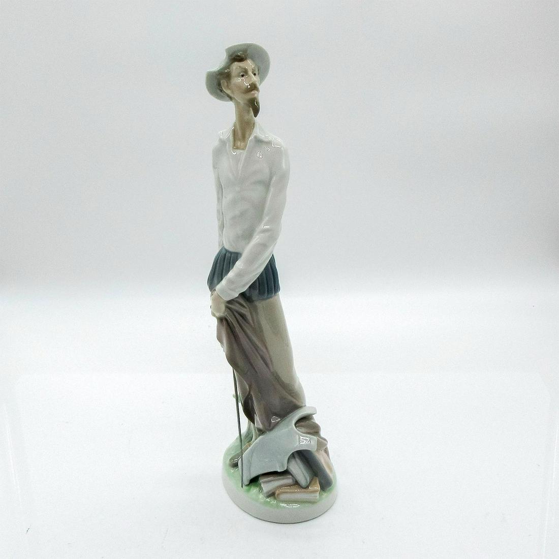 Quixote Standing Up 1004854 - Lladro Porcelain Figurine: Glazed figurine depicting Don Quixote standing, holding a sword, next to armor and books. Lladro backstamp. Artist: Salvador Furio Issued: 1973 Dimensions: 11.75" H Manufacturer: Lladro Country of Ori
