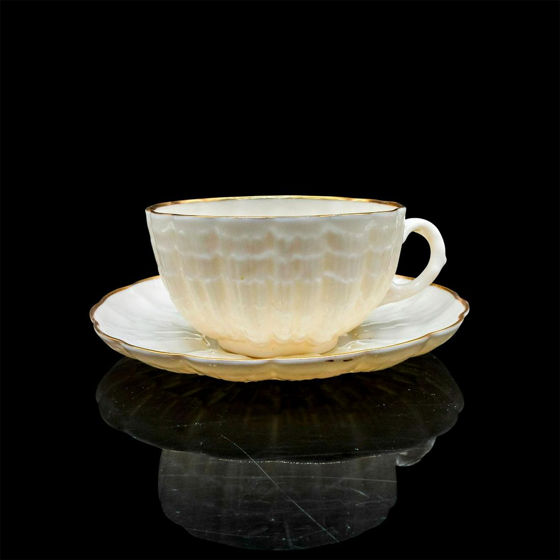 Belleek Porcelain Tea Cup and Saucer: Cream color in scalloped design with gold tone rim. Belleek backstamp. Cup size - 2"H x 3.5" diameter. Saucer size - 5.25" diameter. Issued: 20th c. Manufacturer: Belleek Country of Origin