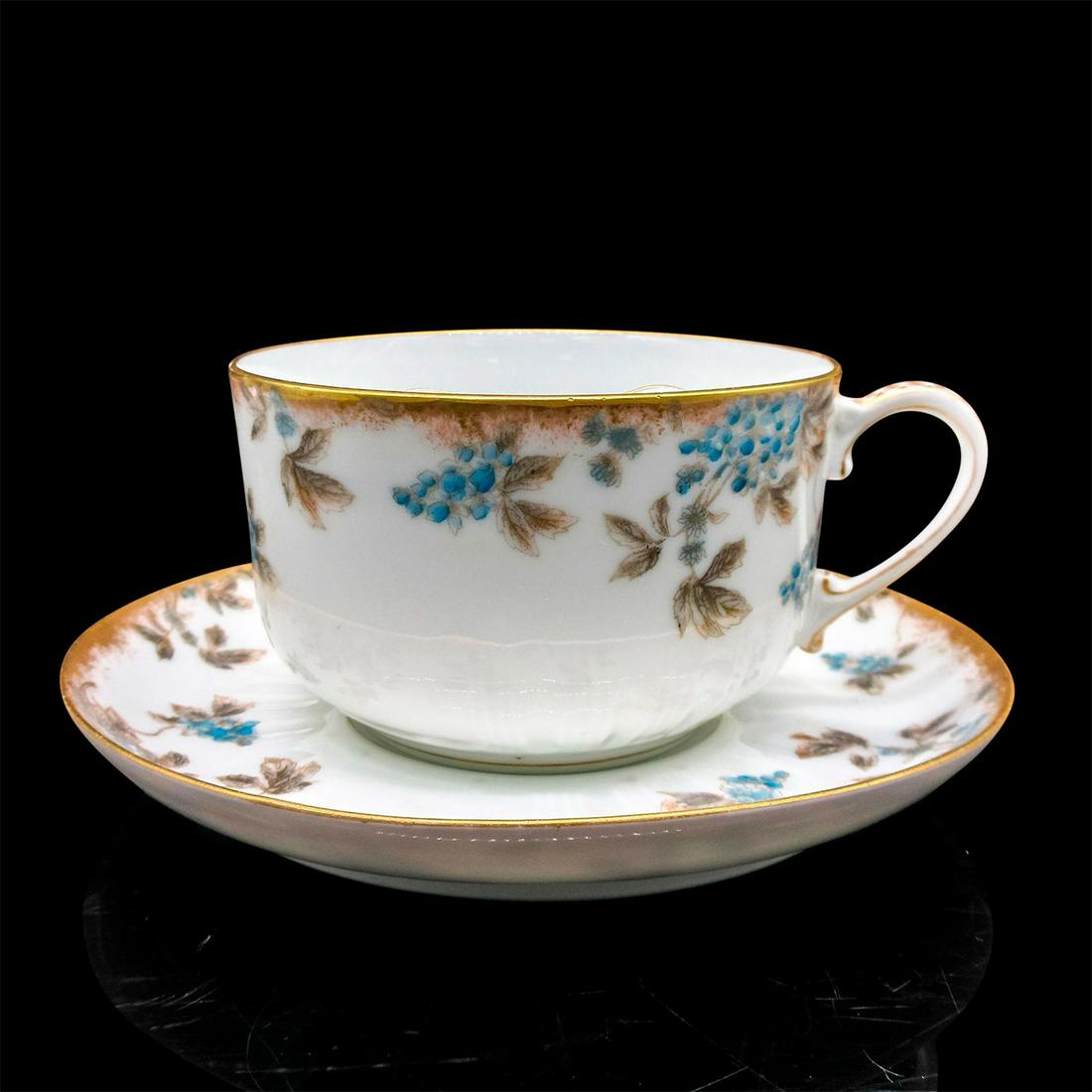 CH Field Haviland Mustache Tea Cup and Saucer: White porcelain with blue and brown floral and leaf design with gold tone rim. CH Field Haviland Limoges backstamp. Cup size - 2.5"H x 4" diameter. Saucer size - 6.25" diameter. Issued: 20
