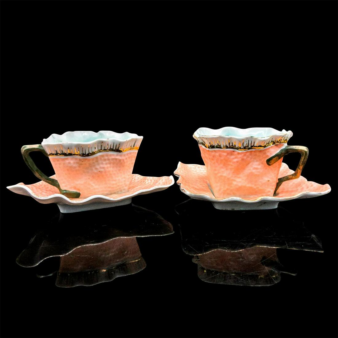 Vintage His and Hers Tea Cup and Saucer Set: Unusual set of square moustache teacup and saucer and triangle cup and saucer. Both teacup exteriors and saucers in pale pink with teacup interiors in seafoam. Gold rims and accents. Moustache partiti