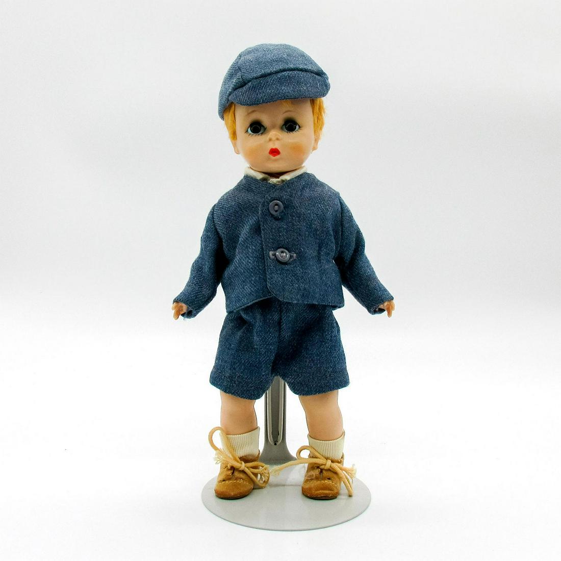 Vintage Madame Alexander Doll, Prince Charles: Vintage doll with blonde hair wearing blue coat and shorts over white shirt. Blue cap and tan shoes included. Stand included. Madame Alexander tags. Issued: 20th c. Dimensions: 8" H Manufacturer: Mada
