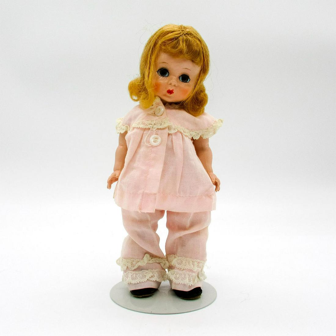Vintage Madame Alexander Doll, Wendy Kin: Vintage doll with curly blonde hair. Light pink pants and shirt with frilly white lace details. Stand included. Madame Alexander tags. Issued: 20th c. Dimensions: 8" H Manufacturer: Madame Alexander C