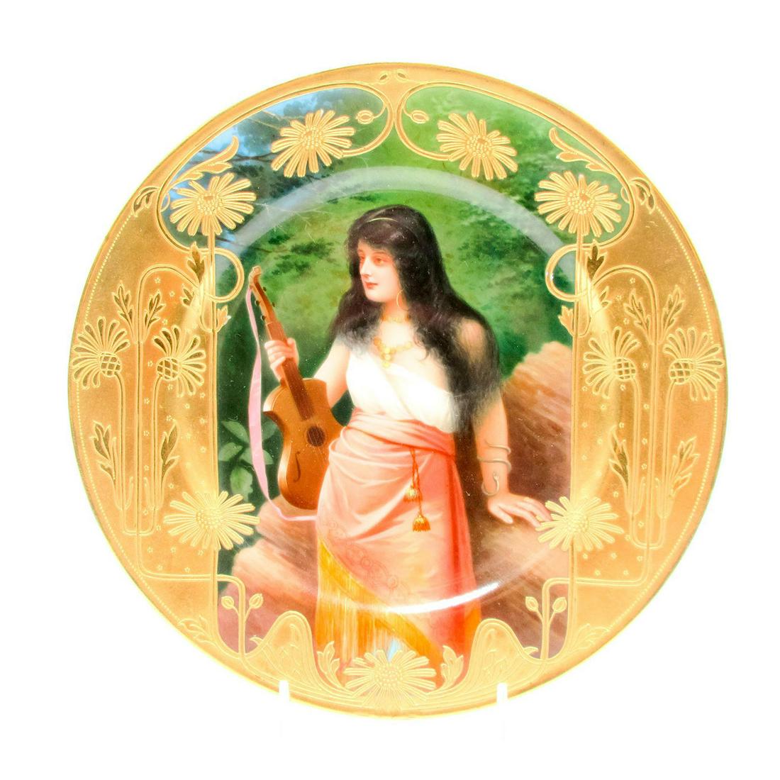 Antique German Gilded Art Nouveau Maiden Charger: Porcelain, hand-painted scene of a gypsy holding an string instrument. Art Nouveau gilt floral border. 0300. Blue backstamp on the base. Dimensions: 9.5" dia.