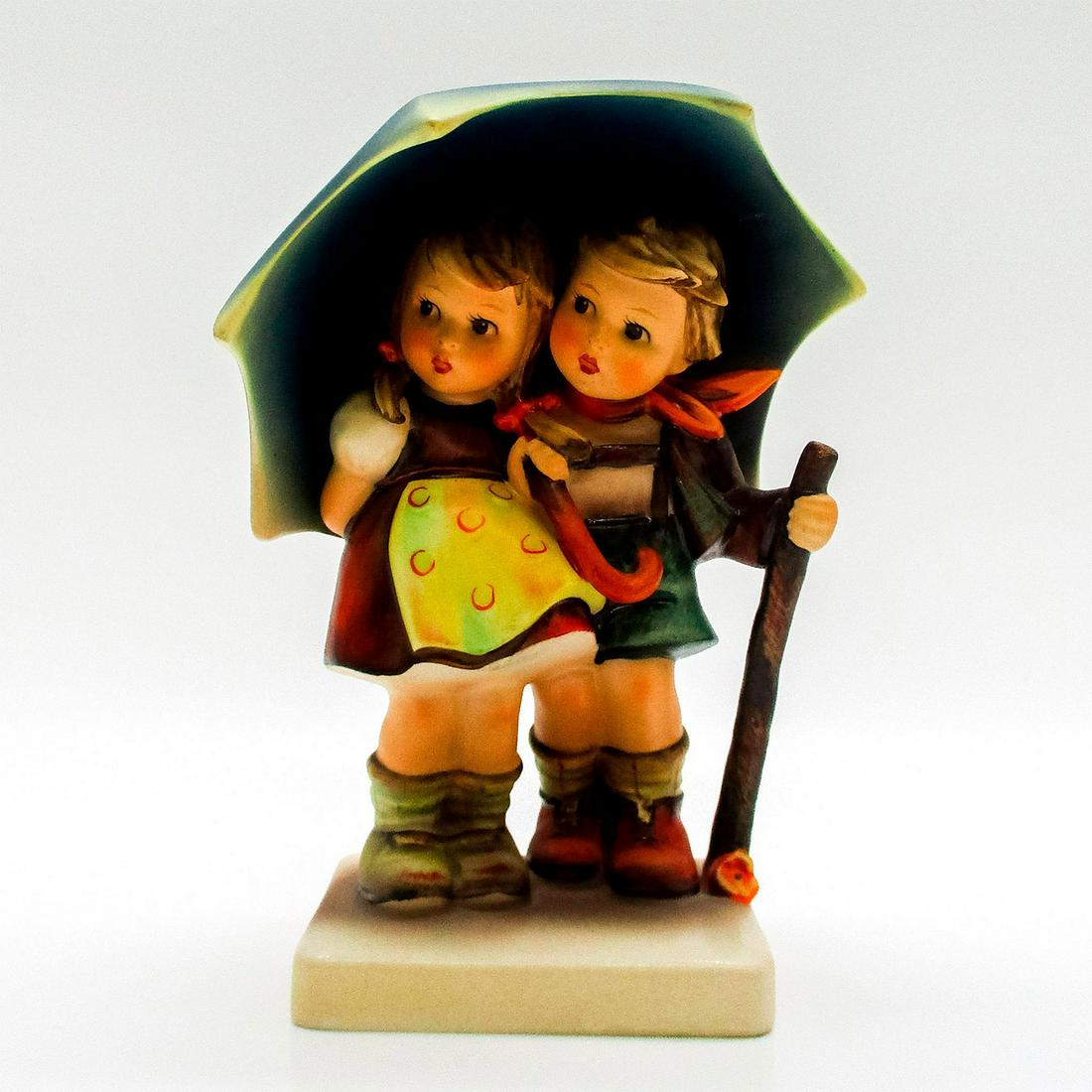 Goebel Hummel Figurine, Stormy Weather: Porcelain hand painted in matte finish. Goebel backstamp. Artist: M. I. Hummel Dimensions: 3" L x 4.25" W x 6" H Manufacturer: Goebel Hummel Country of Origin: Germany