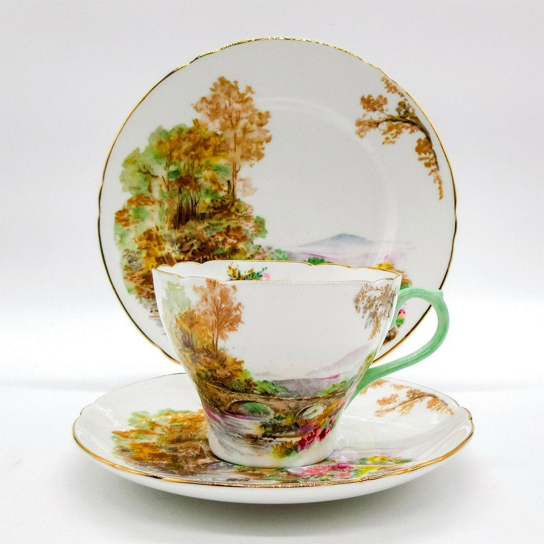 3pc Shelley England Tea Set Trio, Heather: Bone china tea set; Cambridge shape. Fall countryside scenery. Gold gilt accents. Shelley England backstamp. Cup size - 2.5"H x 3.5" diameter (widest). Saucer size - 0.75"H x 5.5" diam
