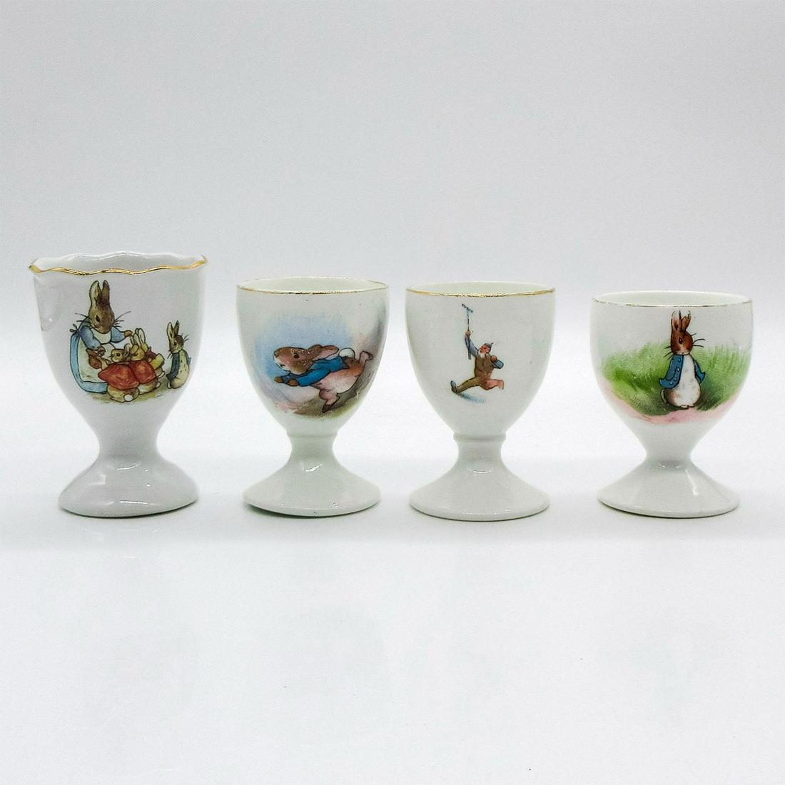 4pc Reutter Porzellan & Grimwades Beatrix Potter Egg Cups: Mini ceramic pieces have gilt accents around rims. Largest measures 3"H while others measure 2.5"H. This item has no reserve. Issued: 20th c. Manufacturer: F. Warne & Co. Country of Origin: Germany &