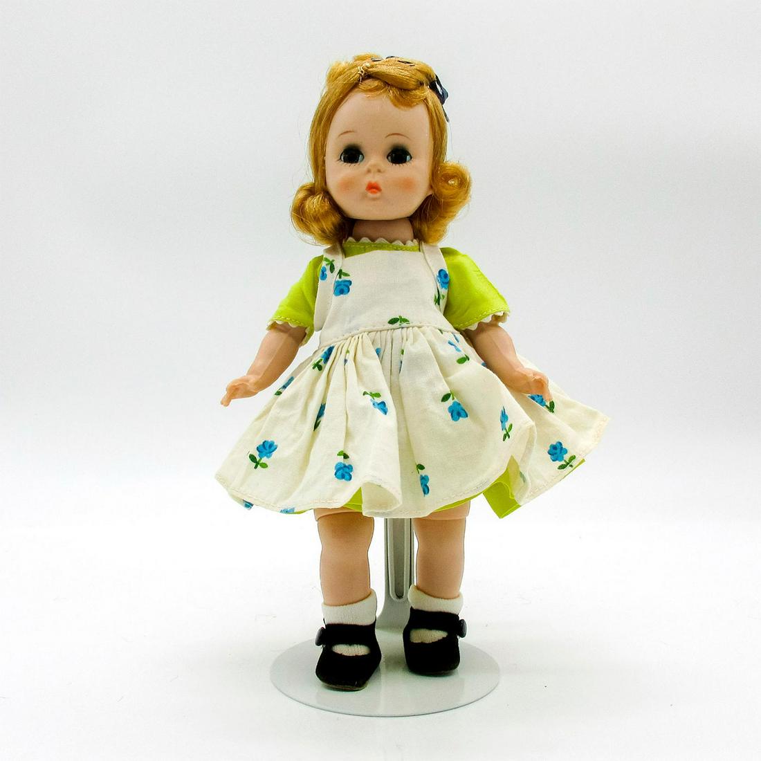 Vintage Madame Alexander Doll, Alexander-kin: Vintage doll with short curly hair. Chartreuse dress with white floral pinafore. Part of the Alexander-kins collection. Alex stamped to back. Dimensions: 8" H Manufacturer: Madame Alexander Country of