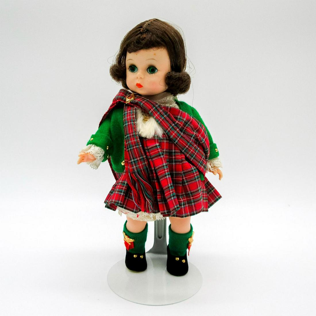Vintage Madame Alexander Doll, Scottish: Dressed in plaid dress with matching sash, green jacket, and black shoes. Madame Alexander backstamp on back. Comes with stand. This item has no reserve. Dimensions: 7.75" H Manufacturer: Madame Alexa